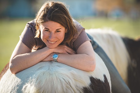 Frau liegt auf Pferd